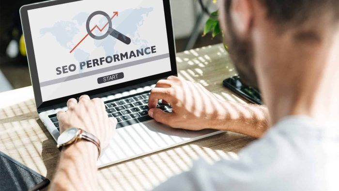 A person types on a laptop displaying "SEO Performance" on the screen, along with a magnifying glass icon and a start button, highlighting the expertise of an SEO company in Toronto.