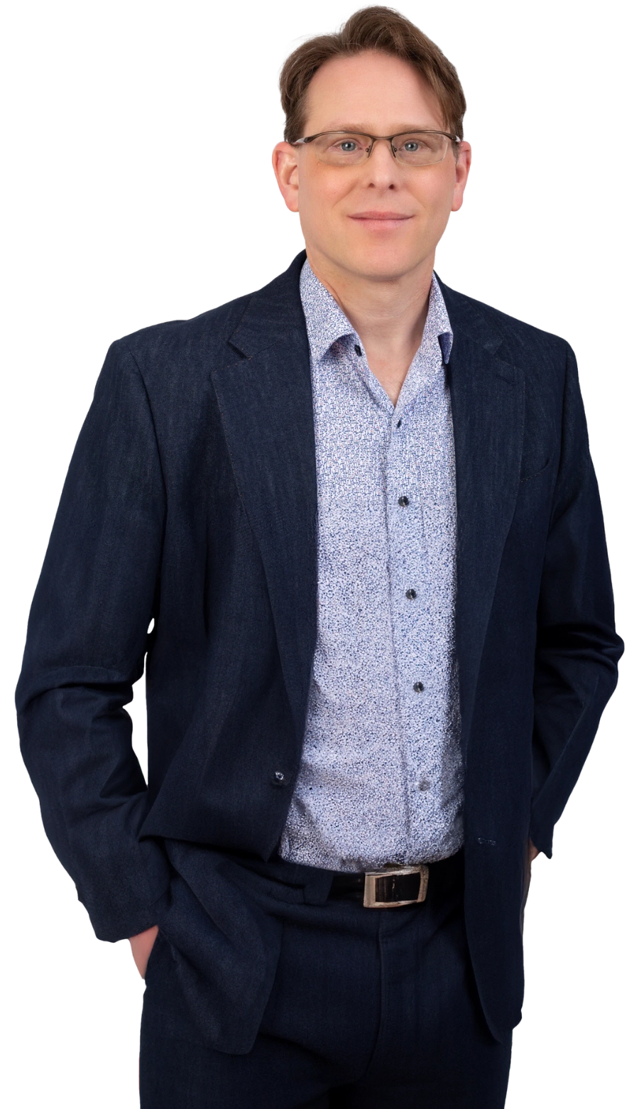 A person wearing glasses, a dark suit, and a patterned shirt stands with hands in pockets, poised like the subject of a branding case study, looking at the camera.