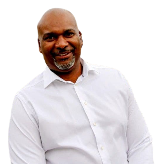 Tony-Ambersley-Header: A man wearing a white button-up shirt stands against a plain white background, smiling at the camera.